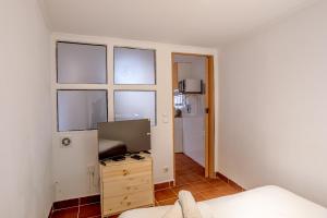 a living room with a tv and some windows at Alfama Tiny by Homing in Lisbon