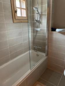 a bathroom with a shower with a glass door at Aux lits du bronze Le mole in Mont-Saxonnex