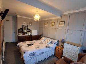 a bedroom with a bed and a chandelier at Newton House in Torquay