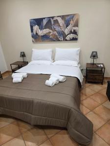 a bedroom with a large bed with towels on it at Monreale Prestige Rooms B&B in Monreale +41 photos