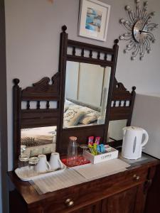 a mirror on top of a wooden dresser at Newton House in Torquay