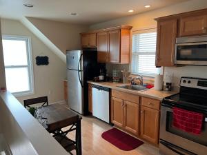 a kitchen with wooden cabinets and a stainless steel refrigerator at Sexy Suite in Cedarburg