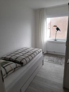 a bed in a room with a bird in a window at Stadtlounge Norden in Norden