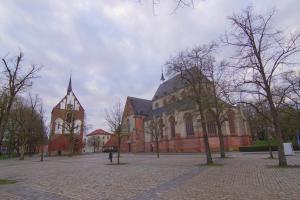 a large brick building with a tower and a church at Stadtlounge Norden in Norden