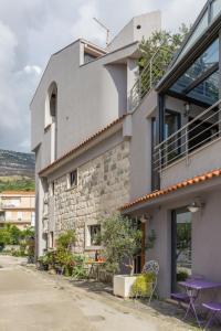 a building with purple chairs and tables outside of it at Apartments Glusac in Podgora