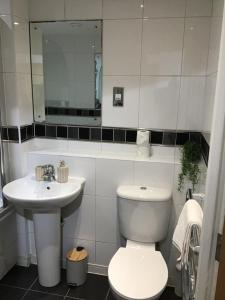 a white bathroom with a toilet and a sink at Olive Den in Wolverhampton +29 photos
