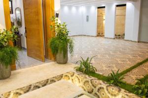 a lobby with potted plants on the floor at Villa Reyna El placer in Baní +26 photos