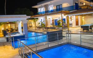 a house with a swimming pool in front of a house at Villa Reyna El placer in Baní