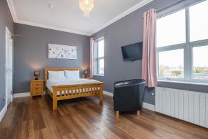a bedroom with a bed and a tv on a wall at Marlborough Hotel in Norwich