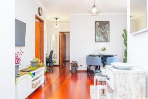 a living room with a wooden floor and a dining room at StayinMachico in Machico