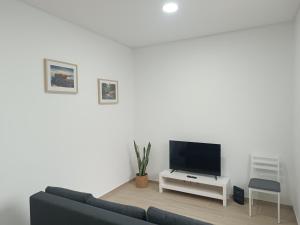 a living room with a couch and a flat screen tv at Cozy Noia in Machico
