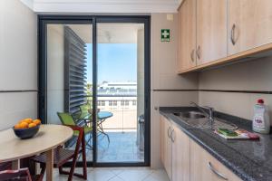 a kitchen with a table and a counter top at Santa Maria Apartamentos in Tavira