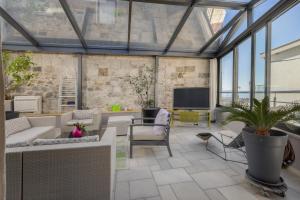 a conservatory with glass ceilings and a living room at Apartments Glusac in Podgora