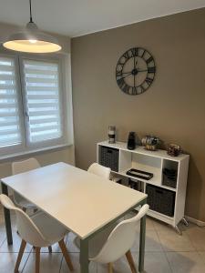a dining room with a table and chairs and a clock at Eporedia Inn in Ivrea +10 photos
