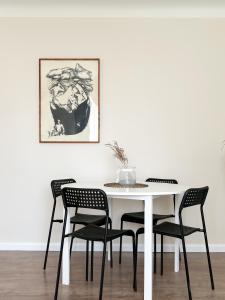 a dining room with a white table and chairs at Sigulda center apartments in Sigulda