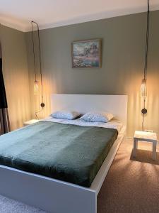 a bedroom with a large bed with two lamps at Sigulda center apartments in Sigulda
