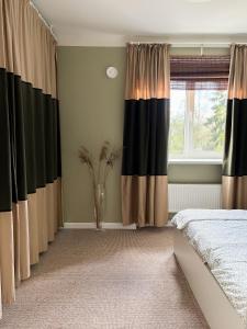 a bedroom with black and brown curtains and a bed at Sigulda center apartments in Sigulda