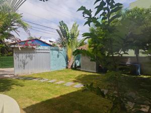 a yard with a blue house and a fence at Casa Jambo Canoa Quebrada in Canoa Quebrada