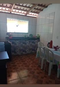 a kitchen with a table and chairs and a window at Recanto Soares in Mucuri