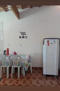 a kitchen with a table and chairs and a refrigerator at Recanto Soares in Mucuri