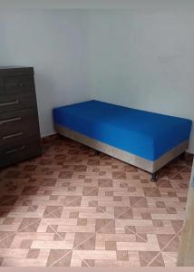 a blue bed in a room next to a dresser at Recanto Soares in Mucuri
