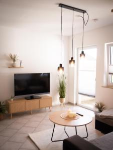 a living room with a large flat screen tv at Ferienwohnung Allgäuherz in Obergünzburg