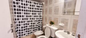 a bathroom with a toilet and a shower curtain with dogs on it at Apex Apart in Mendoza +32 photos