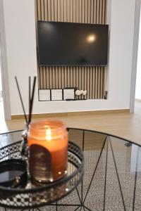 a candle sitting on a glass table in front of a tv at Xenia Residence in Faliraki
