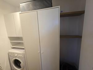 a white closet with a washing machine and a washer at Apatrament Jagielońska in Legnica