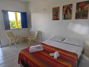 a bedroom with a bed and a table and chairs at Casa Jambo Canoa Quebrada in Canoa Quebrada