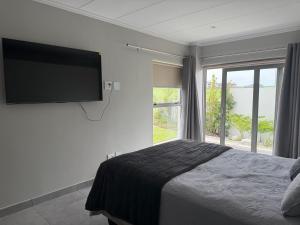 a bedroom with a bed and a large window at 22 Mountain View in Herolds Bay