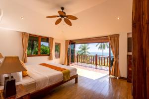 a bedroom with a bed and a balcony at Villa Vadee - Entire Private Villa, 4 Bedrooms, Large Swimming Pool, Ocean View in Thong Nai Pan Noi