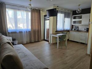 a living room with a couch and a table and a kitchen at Apatrament Jagielońska in Legnica