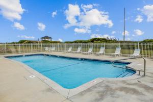 a swimming pool with chairs and a fence at ABOS147 Ocean Sands 136 in Atlantic Beach