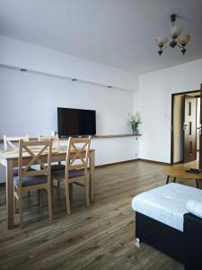 a dining room with a table and chairs and a tv at Apartament Kris in Wałbrzych +13 photos