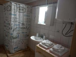 a bathroom with a shower curtain with writing on it at Giannis' House in Polichnítos +8 photos
