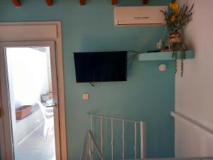 a living room with a television on the wall at Giannis' House in Polichnítos