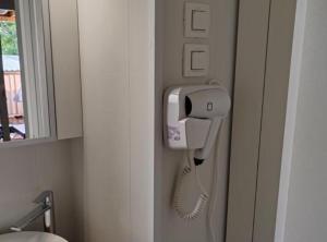 a hair dryer is attached to a wall in a bathroom at Mobile Home Annika Mar in Selce +26 photos