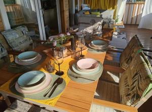 a wooden table with plates and dishes on it at Mobile Home Annika Mar in Selce