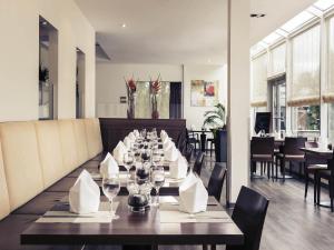a dining room with a long table with wine glasses at Sunday Hotel Saarbrücken Süd in Saarbrücken