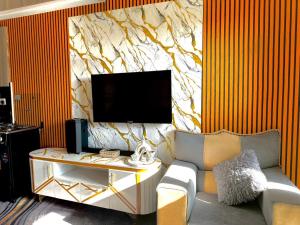 a living room with a couch and a tv on a wall at Shiela inn in Nairobi