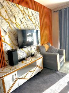 a living room with a couch and a tv at Shiela inn in Nairobi