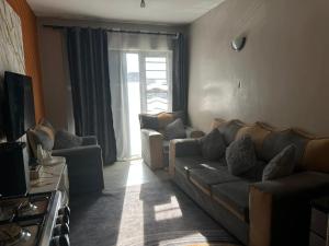a living room with a couch and a window at Shiela inn in Nairobi