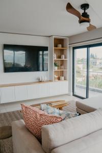 a living room with a couch and a tv at Seaside tranquility in Gonubie in East London