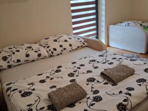 a bed with black and white sheets and pillows at Pokoje u Wojciecha in Tylmanowa