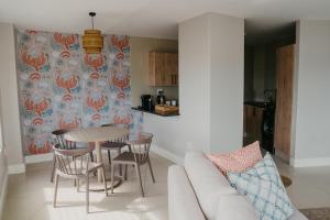 a living room with a couch and a table and chairs at Seaside tranquility in Gonubie in East London
