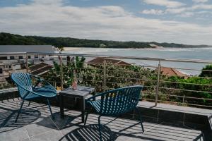 a table and chairs on a balcony with a view of the ocean at Seaside tranquility in Gonubie in East London