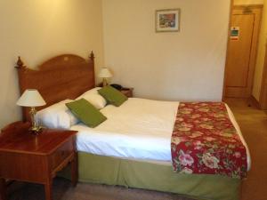 Un pat sau paturi într-o cameră la Troy Hotel