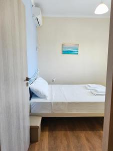a small room with a bed and a painting on the wall at Theros in Makrygialos