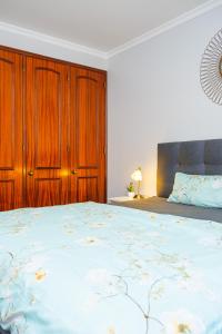 a bedroom with a large bed with a wooden cabinet at StayinMachico in Machico